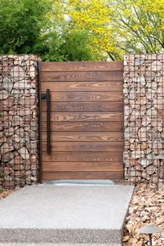 a wooden gate surrounded by rocks and trees