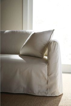 a white couch sitting in front of a window