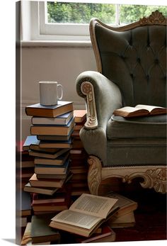 a stack of books sitting on top of a chair next to a cup and book