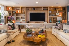 a living room filled with furniture and a flat screen tv mounted on a wall above it