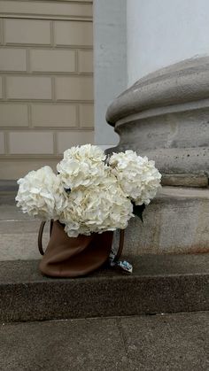 a bunch of white flowers sitting on the ground next to a stone pillar and door