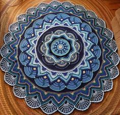 a blue and white doily on top of a brown tablecloth with an intricate design