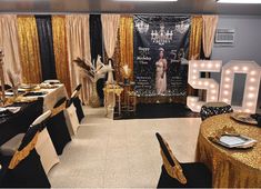 a room filled with tables and chairs covered in gold sequins, black tablecloths and lights