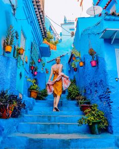 a woman is walking down some steps in the blue city