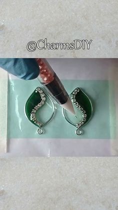 a pair of scissors is being used to cut glass beads on a piece of paper