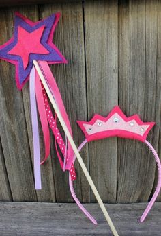 a pink and purple headband with a star on it next to a wooden fence