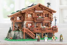 a lego model of a log cabin with people standing outside