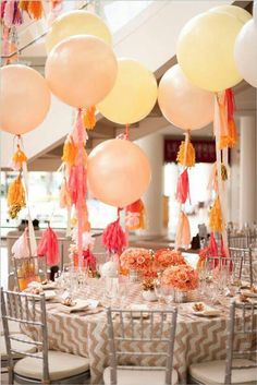 the table is set with many balloons and tassels