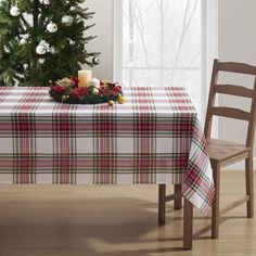 a table with a christmas tree in the background and a plaid tablecloth on it