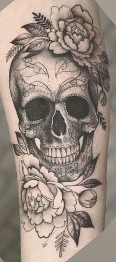 a woman's thigh with a skull and flowers on it