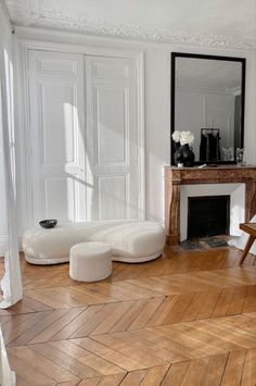 a living room filled with furniture and a fire place next to a mirror on the wall