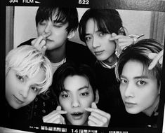 black and white photograph of four young women posing for the camera with their fingers on their lips