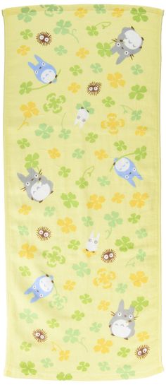 a yellow blanket with blue and white animals on it's sides, surrounded by clover leaves