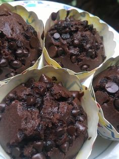 four chocolate muffins sitting on top of a plate