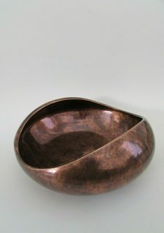 a wooden bowl sitting on top of a white table