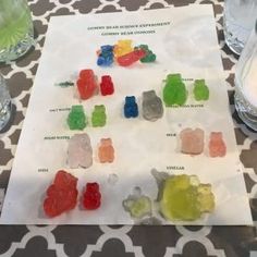 gummy bears sitting on top of a table next to water glasses and a napkin