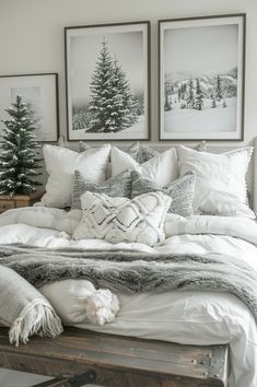 a bed with white comforter and pillows in front of two pictures on the wall