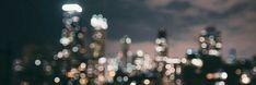 blurry cityscape at night with lights from skyscrapers in the foreground