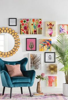 a living room filled with furniture and pictures on the wall behind a blue chair in front of a round mirror