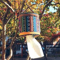 a colorful bird feeder hanging from a tree