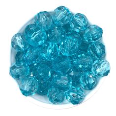 a white bowl filled with blue glass beads