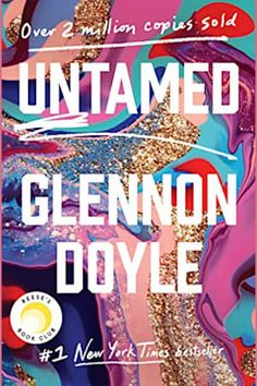 the cover of an untamed novel with gold and blue paint splattered on it