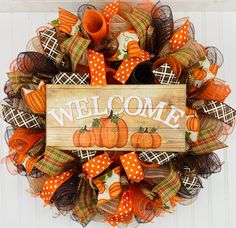 a welcome fall wreath with pumpkins and burlocks