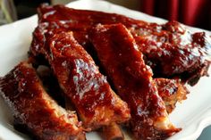 slow cooker sticky ribs on a white plate with red flowers in the background and text overlay