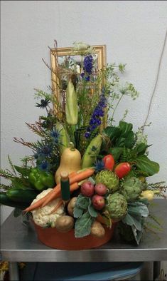 a basket filled with lots of different types of fruits and vegetables on top of a table