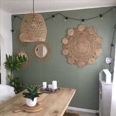 a wooden table topped with plates and bowls next to a wall mounted planter filled with succulents