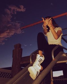 a woman sitting on top of a metal slide