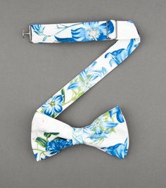 Groomsmen gift ideas. Groom outfit, wedding day gifts for men, groomsmen box with accessories, alcohol, cigar, socks. Men's outfit with suit and tie or bow tie. #weddingday #groomsmen #gifts #suitandtie #suspenders #weddingplanning Groomsman Floral Tie, Navy Blue Groomsmen Suits Floral Tie, Blue Semi-formal Suit And Tie Accessories With Bow Tie, Blue Bow Tie And Suspenders, Blue Floral Bow Tie, Groomsmen Bowtie, Floral Bow Tie