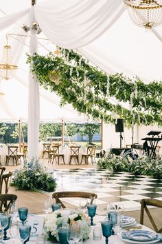 an outdoor tent with tables and chairs set up for a formal function or wedding reception