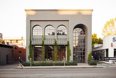 a person walking down the street in front of a building with vines growing on it