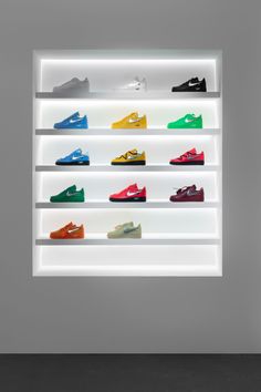 an illuminated display case with many different shoes on it's sides and lights above them