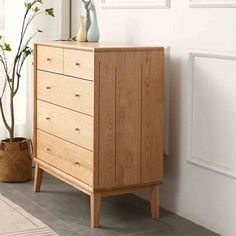 a wooden dresser sitting next to a potted plant