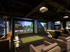 a golf simulator with chairs and television screens