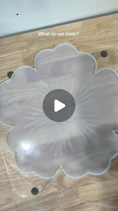 a clear flower shaped bowl sitting on top of a wooden table with the words what do we think?