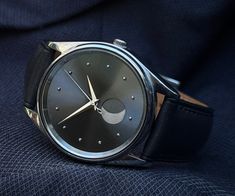 a close up of a watch on a person's lap with the moon in the background