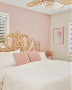 a bedroom with pink walls and white bedding