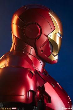 the iron man statue is lit up in the night sky with its head turned to look like it's coming out from behind