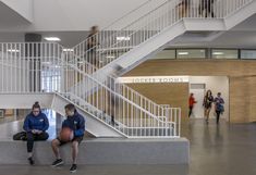 two people sitting on the ground in front of stairs