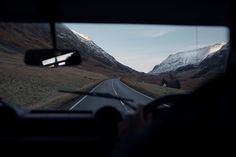 the view from inside a vehicle looking at mountains