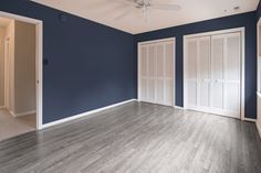 an empty room with blue walls and white shutters