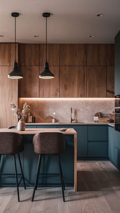 two stools sit in front of a kitchen island with blue cabinets and counter tops