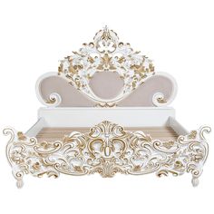 an ornate white and gold bed with a heart shaped headboard on top of it