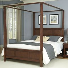 a four poster bed in a bedroom with blue walls