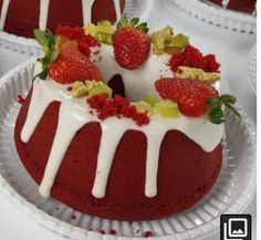 there is a red cake with white icing and strawberries on the top it