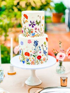 a three tiered cake decorated with colorful flowers