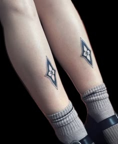 the legs and ankles of a woman with tattoos on her feet, both wearing socks